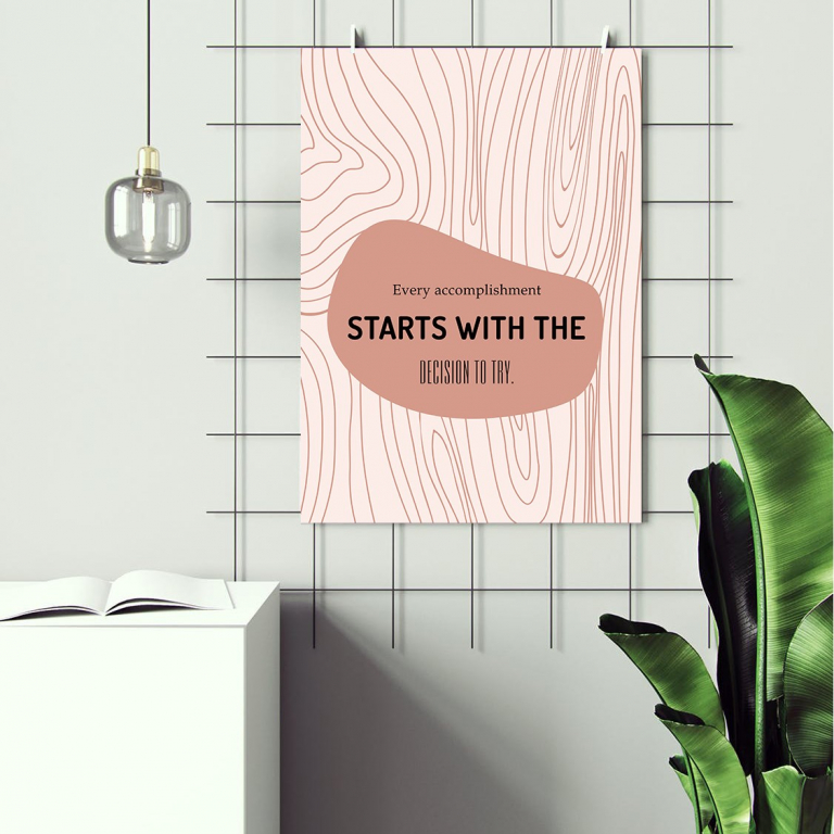 Accomplishment Starts print framed above a desk