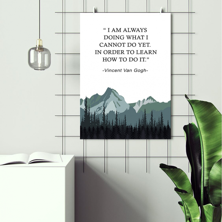 I Am Always Doing print framed above a desk