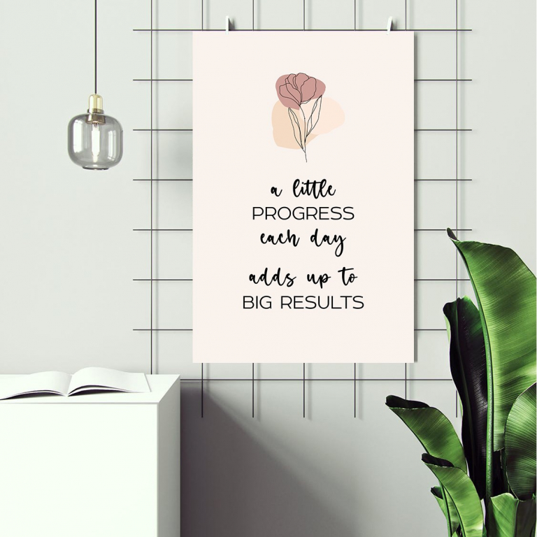 Progress Each Day print framed above a desk