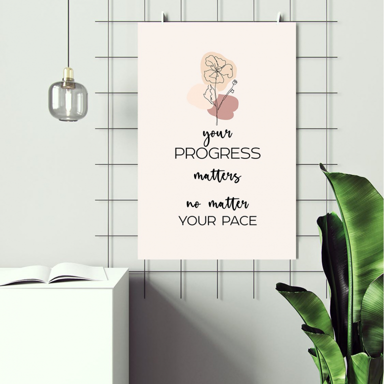 Progress Matters print framed above a desk
