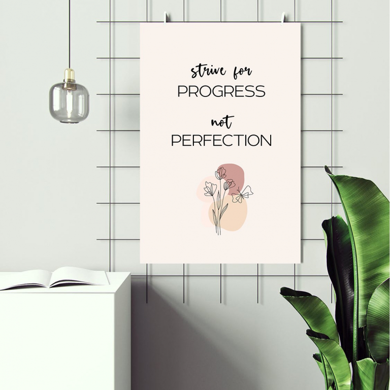 Progress Not Perfection print framed above a desk